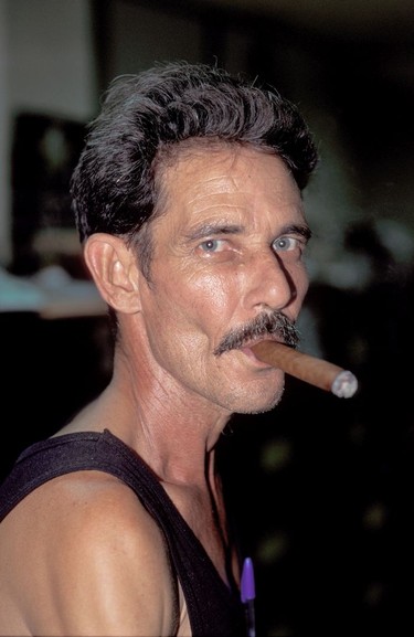 A cigar factory worker enjoys a Cuban cigar.