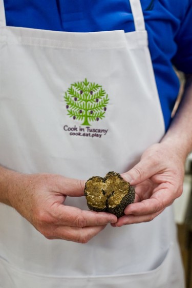 A Cook in Tuscany guest holds a truffle unearthed on a truffle hunt.