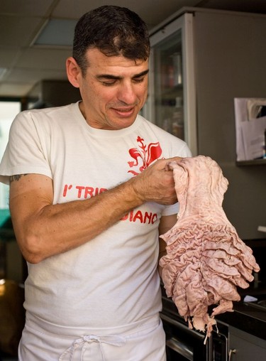 Holding up a cow's stomach, the raw materials that will be turned into lampredotto panino (tripe sandwiches) at the Da Simone food stand, Oltrarno district, Florence.