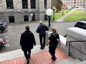 Two key officials at British Columbia's legislature were placed on indefinite leave today and were escorted out of the building by police.