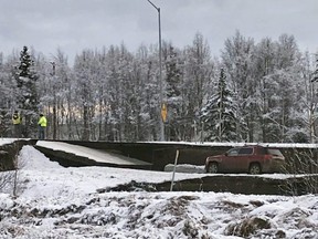 A car is trapped on a collapsed section of the offramp off of Minnesota Drive in Anchorage, Alaska Friday, Nov. 30, 2018.