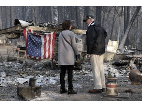 President Donald Trump talks to Mayor Jody Jones as he visits a neighborhood impacted by the wildfires, Saturday, Nov. 17, 2018, in Paradise, Calif.