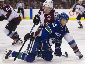 Vladislav Kamenev of the Colorado Avalanche holds Elias Pettersson of the Vancouver Canucks down during Friday's NHL game at Rogers Arena. Pettersson rose up in a big way as the Canucks won 7-6 in overtime.