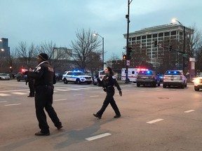 Chicago Police officers walk outside Mercy Hospital on the city's South Side where authorities say a shooting at the hospital has wounded multiple people, including a suspect and a police officer, Monday, Nov. 19, 2018, in Chicago.