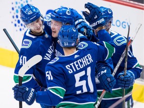 Vancouver Canucks' Elias Pettersson, of Sweden, from left to right, Brock Boeser, Troy Stecher and Nikolay Goldobin, of Russia, celebrate Boeser's second goal against the Colorado Avalanche during the second period of an NHL hockey game in Vancouver, on Friday November 2, 2018.