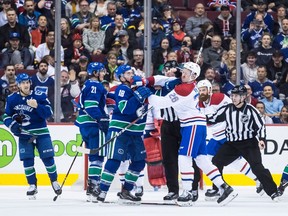 Vancouver Canucks' Jake Virtanen (18) and Montreal Canadiens' Jeff Petry (26) get into a scuffle during third period NHL hockey action in Vancouver on Saturday, Nov. 17, 2018.