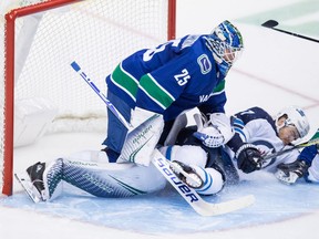 Winnipeg Jets' Adam Lowry crashes into Canucks goalie Jacob Markstrom during NHL action in Vancouver on Nov. 19.