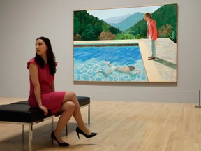 In this Feb. 6, 2017, file photo, a Tate representative poses for photographs next to British artist David Hockney's "Portrait of an Artist (Pool with Two Figures) during a photo call to promote the largest-ever retrospective of his work at Tate Britain gallery in London.