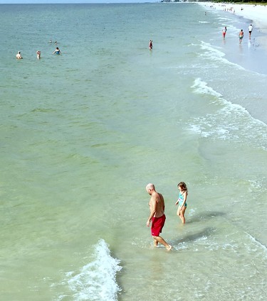 Swimmers enjoy the tranquil Gulf of Mexico waters at Naples Beach in Southwest Florida.