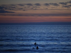 Two surfers wait for a wave in the Pacific Ocean at Sunset Beach in Pacific Palisades, Calif., Thursday, Jan. 4, 2018.