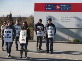 Striking postal workers walk the picket line at the Canada Post Pacific Processing Centre in Richmond, BC Saturday, November 10, 2018. The rotating strike, in effect since October 22, has affected mail delivery across the country. Negotiations continue.