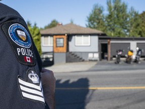 A member of the Combined Forces Special Enforcement Unit of B.C. monitors the Nanaimo Hells Angels clubhouse on July 20, 2018. A lawyer for the Hells Angels claimed on April 9, 2019, that the RCMP just wanted to get 'bad guys' by recommending that the government seek civil forfeiture of one of the notorious motorcycle gang's clubhouses.