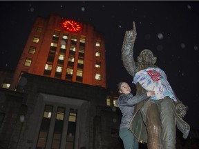 VANCOUVER November 27 2018.   Maddy Andrews with the Vancouver Tenants Union ties a " Rent Freeze Now " t-shirt on the statue of Captain Vancouver outside city hall, Vancouver,  November 27 2018.   Gerry Kahrmann  /  PNG staff photo) 00055449A [PNG Merlin Archive]