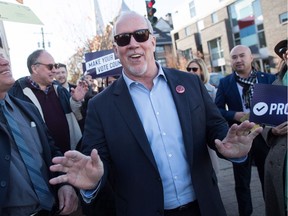 B.C. Premier John Horgan, right, walks to a mailbox with people mailing their electoral reform referendum ballots after a rally in Vancouver on Sunday, Nov. 18, 2018