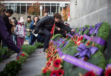 Boy Scout Nick Pinton, 12, places his poppy on a wreath at the Victory Square Cenotaph after a Remembrance Day ceremony in Vancouver, on Sunday, November 11, 2018.