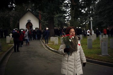 Diana Morris brings flowers to her late father and Merchant Marine Leslie Morris's gravestone during a Remembrance Day ceremony at God's Acre Veteran's Cemetery in Victoria on Sunday, November 11, 2018.