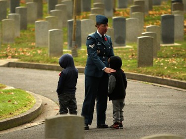 Cpl. Susan Forsberg comforts her children during a Remembrance Day ceremony at God's Acre Veteran's Cemetery in Victoria on Sunday, November 11, 2018.