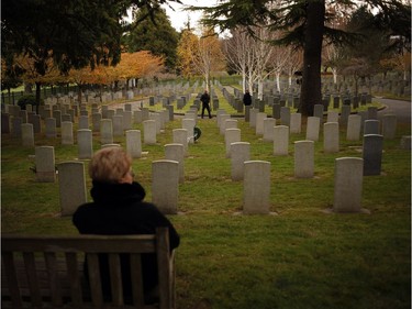 A woman overlooks headstones at God's Acre Veteran's Cemetery during a Remembrance Day ceremony in Victoria on Sunday, November 11, 2018.