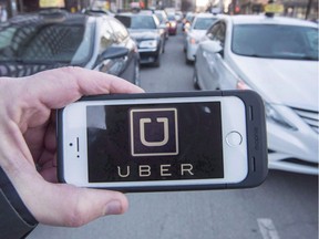 Ride-hailing companies could begin operations in British Columbia by next fall under legislation introduced today. The Uber logo is seen in front of protesting taxi drivers at the courthouse in Montreal, Tuesday, Feb. 2, 2016.