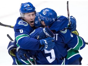 Vancouver Canucks Brock Boeser, from left, Elias Pettersson and Derrick Pouliot celebrate Pouliot's winning goal against the Colorado Avalanche during overtime NHL action at Rogers Arena on Friday, Nov. 2, 2018.