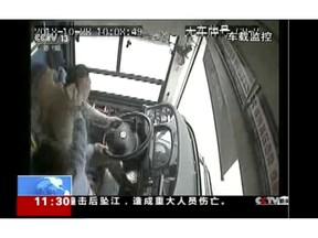 In this image taken from Sunday, Oct. 28, 2018 surveillance video footage run by China's CCTV via AP Video, a passenger strikes a bus driver with an object moments before the bus plunged off a bridge into the Yangtze River.