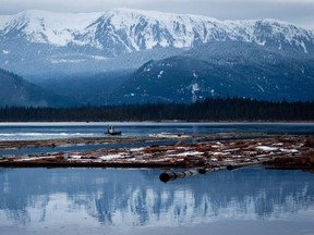 File: A worker uses a small boat to move logs on the Douglas Channel at dusk in Kitimat, B.C., on Jan. 11, 2012. Douglas Channel was the proposed termination point for Enbridge’s now-defunct Northern Gateway pipeline project.