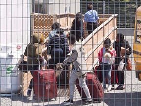 A group of asylum seekers arrive at the temporary housing facilities at the border crossing Wednesday May 9, 2018 in St. Bernard-de-Lacolle, Que.