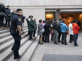 A B.C. Supreme Court sheriff watches over the crowd waiting in line to enter the courtroom to watch the bail hearing for Huawei Technologies CFO Meng Wanzhou on December 10, 2018 in Vancouver, Canada.