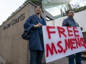 Supporters Ada Yu and Wade Meng (no relation) stand with a sign outside B.C. Supreme Court before the bail hearing for Huawei Technologies CFO Meng Wanzhou on December 10, 2018 in Vancouver, Canada. Wanzhou is accused of fraud stemming from violating U.S. sanctions on Iran.