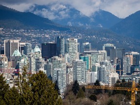 A crane is seen at a condo development under construction as condo and office towers fill the downtown skyline in Vancouver on March 30, 2018.