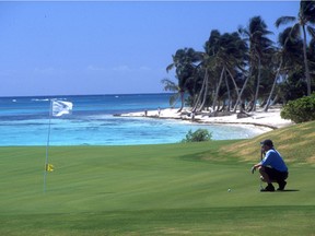 A golfer lines up a putt on the 18th green at  La Cana Golf Course at Punta Cana Resort.