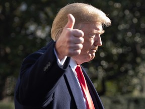 File: Donald Trump gives a thumbs-up as he speaks to the press as he walks to Marine One prior to departing from the South Lawn of the White House in Washington, DC, December 7, 2018.