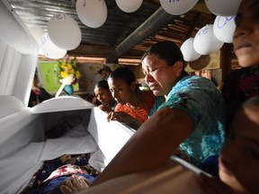 File: Relatives cry over the coffin of 7-year old Jakelin Caal, who died in a Texas hospital two days after being taken into custody by border patrol agents in a remote stretch of the New Mexico desert, during the wake in her home village of Raxruha in Alta Verapaz department, 320 km north of Guatemala City, on December 24, 2018. - Jakelin Caal died after being arrested with her father and others crossing from Mexico on December 6. Together they had traveled more than 3,000 kilometers from their hometown of Raxruha, Guatemala. According to local media citing US Customs and Border Protection, the cause of death was "dehydration and shock".
