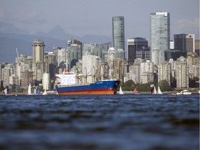 File photo: An ocean going freighter sits at anchor in English Bay in July 2018.