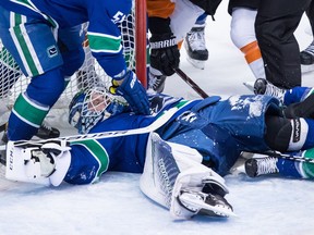 Vancouver Canucks goalie Jacob Markstrom, of Sweden, lies on the puck after making a save against the Philadelphia Flyers during the second period of an NHL hockey game in Vancouver, on Saturday December 15, 2018.