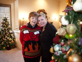 Joyce Wilson, left, and her daughter Lori-Ann Keenan share a moment in mom's living room by a couple of the 17 decorated Christmas trees in Wilson's Richmond home.