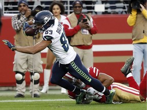 Wide receiver Doug Baldwin of the Seattle Seahawks runs toward the end zone during last Sunday's NFL game against the San Francisco 49ers. Linebacker Fred Warner tries to tackle the Seattle star. The 49ers won in overtime.