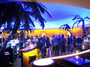 Guests enjoy the vintage charm and atmosphere that includes palm trees and a starry sky above at the Tiki bar in the Waldorf Hotel in 2010.