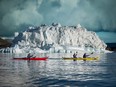Two kayaks pass an iceberg in Disko Bay near Oqaatsut in Greenland.
