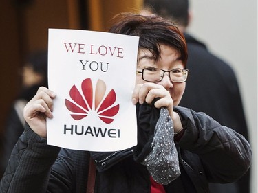 A woman holds up a sign in support of Huawei at a B.C. courthouse prior to the bail hearing for Meng Wanzhou, Huawei's chief financial officer on Monday, December 10, 2018.