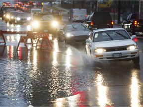 A car drives through a portion of the flooded roadway on Gilmore Ave, Burnaby,  December 13 2018.