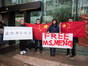 Supporters hold signs and Chinese flags outside B.C. Supreme Court during the third day of a bail hearing for Meng Wanzhou, the chief financial officer of Huawei Technologies, in Vancouver, on Tuesday December 11, 2018.
