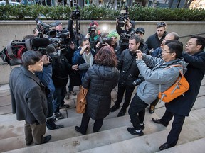 Members of the media crowd around an unidentified woman who was attending a bail hearing for Meng Wanzhou, the chief financial officer of Huawei Technologies, during a break in proceedings at B.C. Supreme Court in Vancouver, on Friday December 7, 2018. She was arrested Saturday after an extradition request from the United States while in transit at the city's airport.