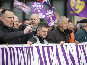 Tommy Robinson, front center, attends the "Brexit Betrayal Rally", a pro-Brexit rally, on Park Lane in London, Sunday, Dec, 9, 2018. MP's are to vote on the EU withdrawal agreement on Tuesday.
