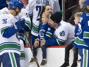Antoine Roussel #26 of the Vancouver Canucks shares a laugh with teammate Sam Gagner #89 and his son Cooper during the Vancouver Canucks Super Skills Contest at Rogers Arena in Vancouver, BC, December, 2, 2018.