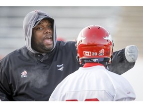 Defensive line coach DeVone Claybrooks offers some guidance for Brandon Smith during a Calgary Stampeders practice at McMahon Stadium in Calgary, Alta. on Wednesday, Nov. 19, 2014.