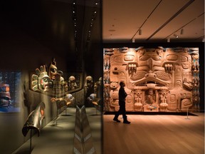 First Nations masks are displayed behind glass as a man walks past The Dance Screen (The Scream Too)"- a red cedar panel by Haida master carver James Hart, at the Audain Art Museum in Whistler.