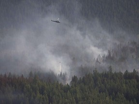 A helicopter dumps a load of water on the Philpot Road fire near Kelowna in August 2017.