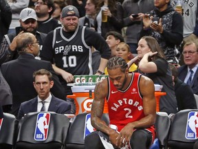 Raptors' Kawhi Leonard sits on the bench during a time-out against the San Antonio Spurs on Thursday. (GETTY IMAGES)