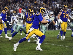 L.A. Rams quarterback Jared Goff rushes for a first down to keep the ball and run out the clock against Dallas Cowboys during the fourth quarter of the NFC Divisional Playoff game at Los Angeles Memorial Coliseum on Saturday.